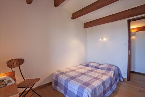a small bedroom with a bed and a chair at Casa Poggio in Barbaggio