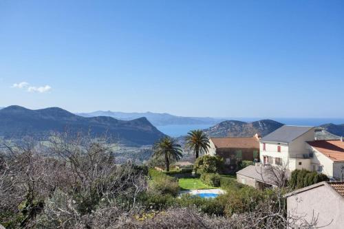 a house with a view of the water and mountains at Casa Poggio in Barbaggio