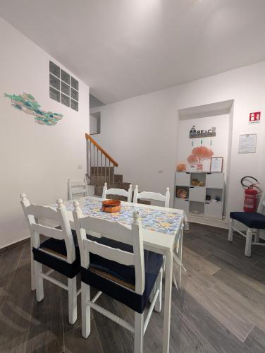 a dining room with a white table and chairs at BELVEDERE apartment in Scilla