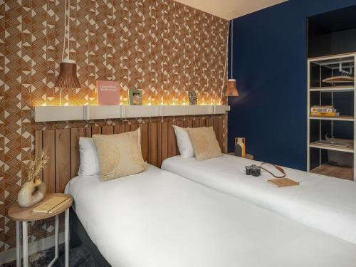 two beds sitting next to each other in a room at Ibis Paris Gare Montparnasse Catalogne in Paris