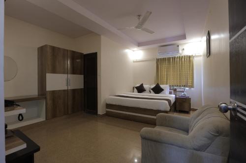 バンガロールにあるHotel Parkview Innのベッドとソファのあるホテルの部屋