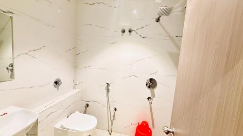 a white bathroom with a toilet and a sink at Hotel City Inn 2min Walk To Gorakhnath Temple in Gorakhpur