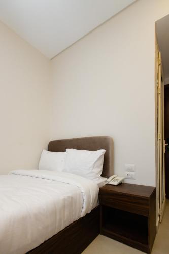 a bedroom with a bed and a phone on a table at Imperial Luxury Hotel in Cairo
