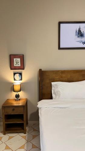a bedroom with a bed and a table with a lamp at Ay’s House in Chiang Mai