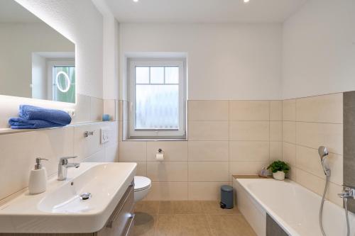 a bathroom with a tub and a sink and a toilet at Kanalkajüte Theodor in Hanerau-Hademarschen