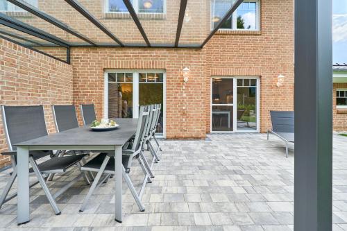 a patio with a table and chairs and a brick building at Kanalkajüte Theodor in Hanerau-Hademarschen