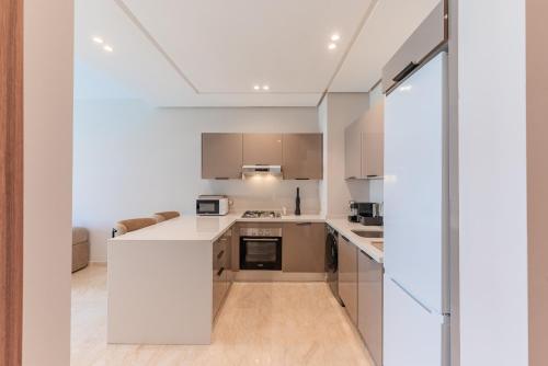 an open kitchen with white cabinets and appliances at L'Horizon - 1 BR - Pool & Terrace in Nouaseur