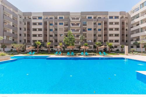 a swimming pool in front of a large apartment building at L'Horizon - 1 BR - Pool & Terrace in Nouaseur