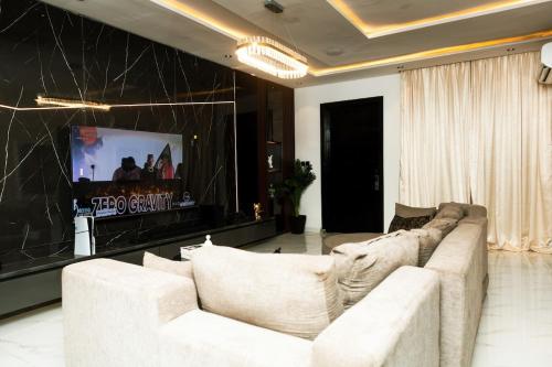 a living room with a white couch and a tv at Oasis Beautiful 2 Bedroom Shortlet Apartment in Lekki
