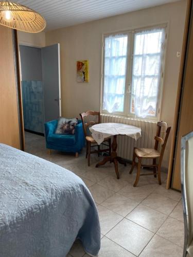 une chambre avec un lit, une table et des chaises dans l'établissement La maison bleue, à Sauveterre-la-Lémance