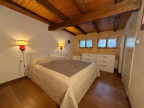 a bedroom with a bed in a room with wooden ceilings at Casa Latemar in Moena
