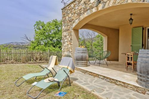 un patio con sillas, una mesa y un barril en Casa U Castagnettu, en Patrimonio