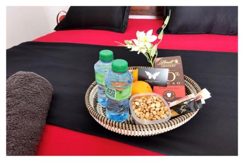 a tray with two bottles of water and food on a bed at La MAISON BLANCHE - Ch2A - CENTRAL - CALME - WIFI - White Butterfly Hotels in Dakar