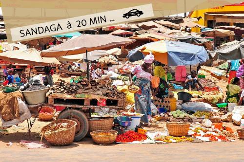 a market with a bunch of vegetables and umbrellas at La MAISON BLANCHE - Ch2A - CENTRAL - CALME - WIFI - White Butterfly Hotels in Dakar