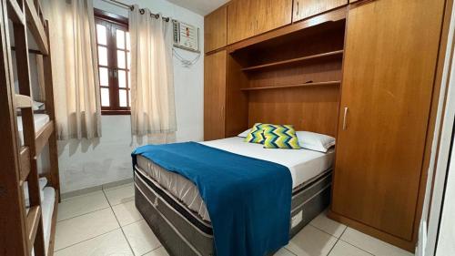 a small bedroom with a bed and a shower at Hostel Arraial in Arraial do Cabo