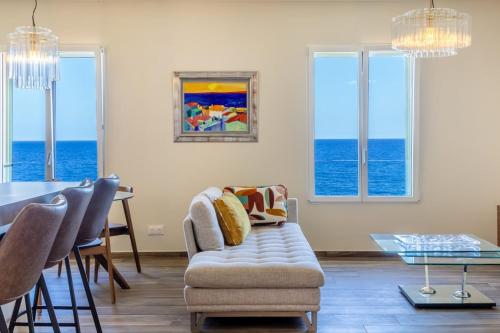 ein Wohnzimmer mit Tisch und Stühlen und dem Meer in der Unterkunft Casa Bordimare Miomo Cap Corse in La Vasina