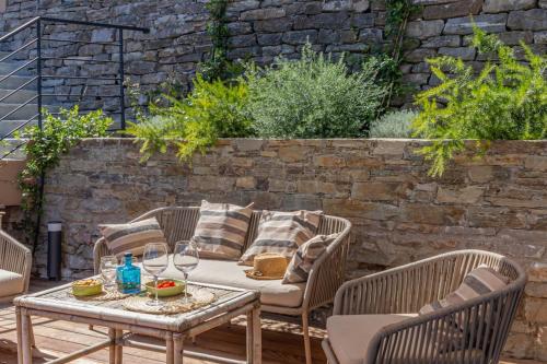 eine Terrasse mit Tisch und Stühlen und einer Backsteinmauer in der Unterkunft Casa Bordimare Miomo Cap Corse in La Vasina