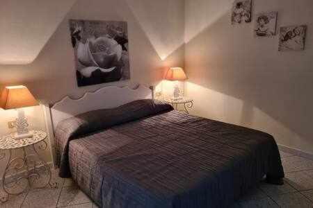 a bedroom with a bed and two lamps on the wall at Appartamento a picco sul mare "La Meridiana" in Capoliveri