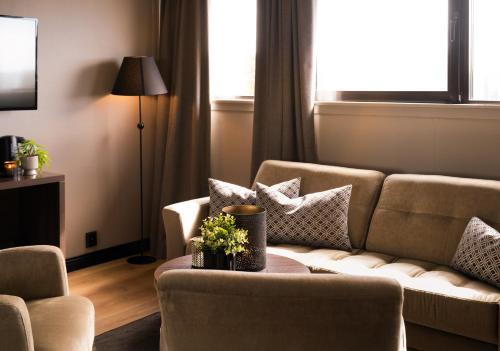 a living room with a couch and a table at Ågotnes Hotell in Ågotnes