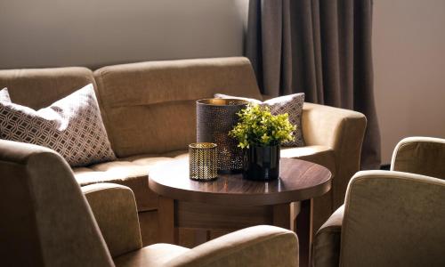 a living room with a couch and a table with flowers at Ågotnes Hotell in Ågotnes