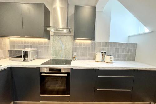 uma cozinha com armários pretos e um micro-ondas em Cottage - Sleeps 2 - Pet friendly - Parking em Windermere