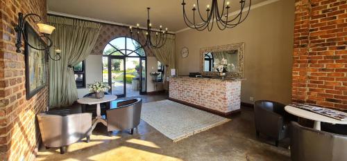 a dining room with two tables and chairs and a brick wall at Beds Inn Midrand in Midrand