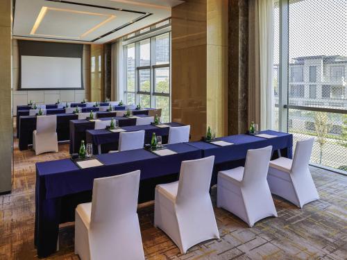 a conference room with blue tables and white chairs at Pullman Suzhou Taicang in Taicang