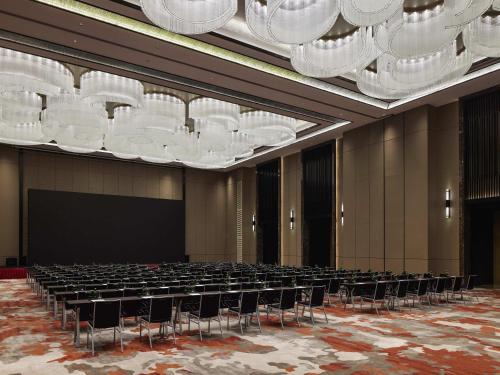 a large room with chairs and chandeliers at Pullman Suzhou Taicang in Taicang