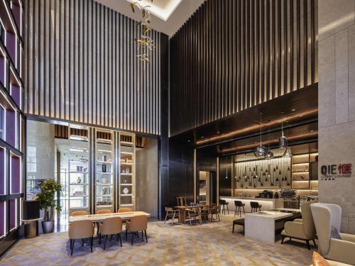 a lobby with tables and chairs and a wine cellar at Pullman Suzhou Taicang in Taicang