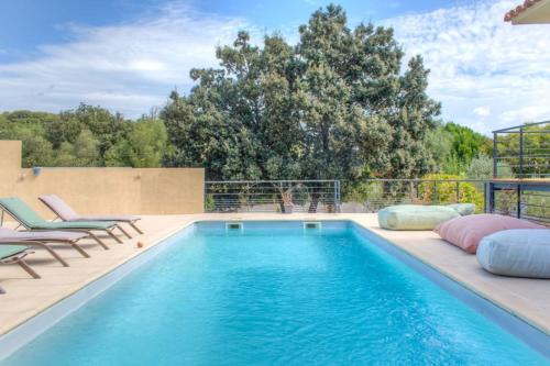 una piscina con dos tumbonas y una piscina en Villa Mathilda Di Porto-Vecchio, en Lecci