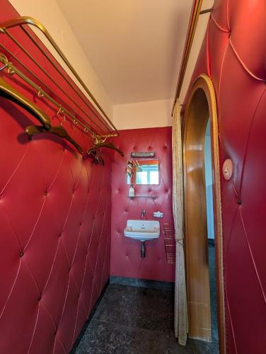 a red bathroom with a sink and a mirror at Gartenoase in Göppingen
