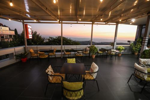 a patio with a table and chairs on a roof at Backpacker Hostel Kruje in Krujë