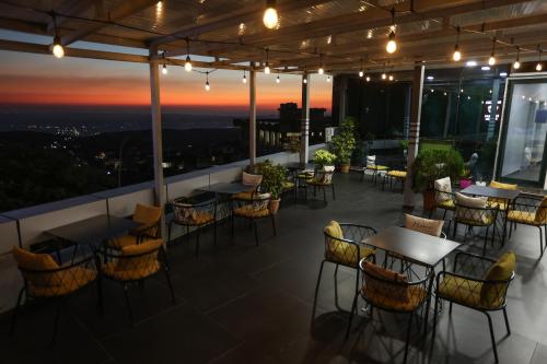 a restaurant with tables and chairs on a balcony at night at Backpacker Hostel Kruje in Krujë