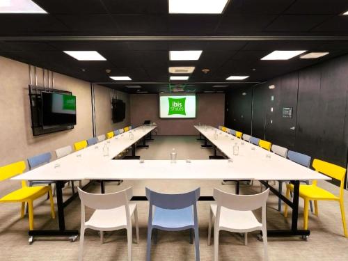 a large conference room with white tables and yellow chairs at ibis styles Lima San Isidro in Lima