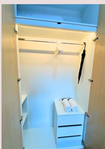 a white closet with two towels on a shelf at Chalong pool villa in Ban Na Bon