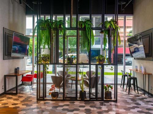 a room with chairs and potted plants in a building at ibis styles Lima San Isidro in Lima