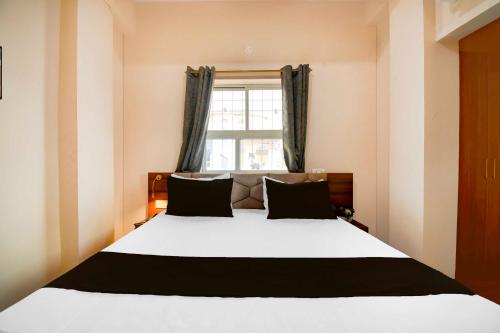 a bedroom with a large bed with a window at Collection O Collection O Kumhrar Archeological Park Hotel Karuna Palace in Patna