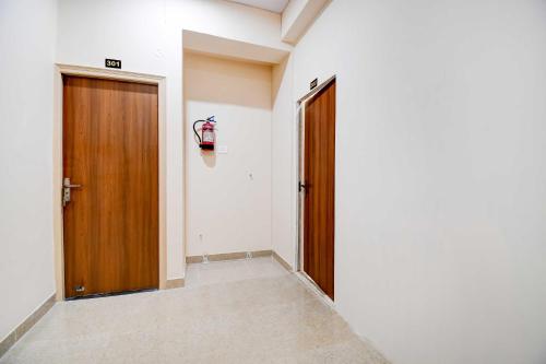 an empty hallway with a door and a fire extinguisher at Collection O Collection O Kumhrar Archeological Park Hotel Karuna Palace in Patna