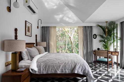 a bedroom with a bed and a desk and a window at La Macedo, Luxury 3 BHK Villas in Assagao, with Private Pool, Garden, Terrace, Parking, Security in Mapusa