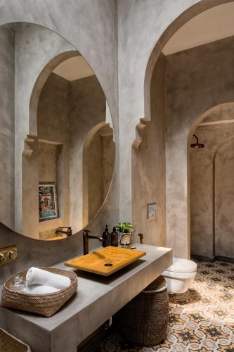 a bathroom with a sink and a toilet and a mirror at La Macedo, Luxury 3 BHK Villas in Assagao, with Private Pool, Garden, Terrace, Parking, Security in Mapusa