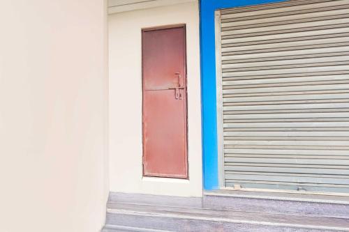 a door on the side of a building with a shutter at Hotel O Prabhat Nagar Bareilly in Bareilly