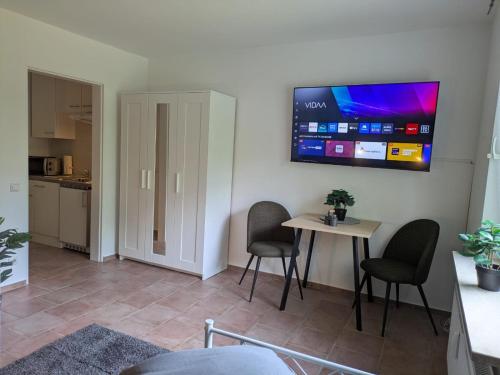 a living room with a table and chairs and a tv at LUTZ Appartements - Südheide in Gifhorn