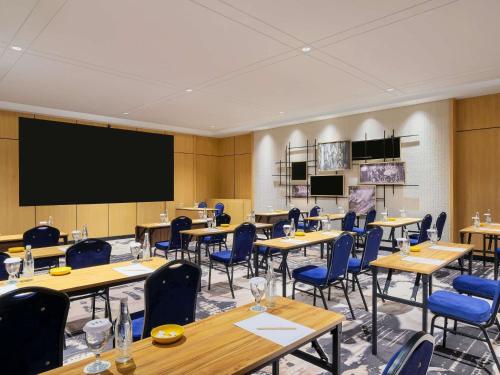 a classroom with tables and chairs and a projection screen at Mercure Tangerang Centre in Tangerang