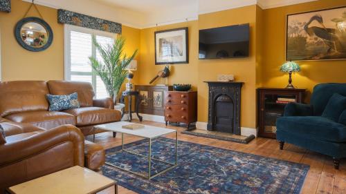a living room with a couch and a fireplace at Paradise Penthouse in Downham Market