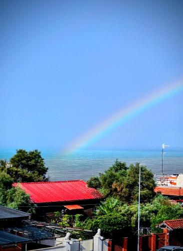a rainbow in the sky with a building and the ocean at A C Tourist Accommodation in Torvaianica