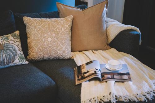 a blanket sitting on a couch with books and a coffee cup at The Underwood-Hale House in Providence