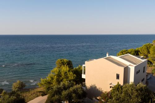 a house by the ocean with a view at Nomia Villa, with Pool, Gym & Walk to the Beach, By ThinkVilla in Alikanas