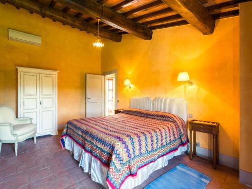 a bedroom with a bed and a chair at Tuscan Charm in Greve in Le Bolle
