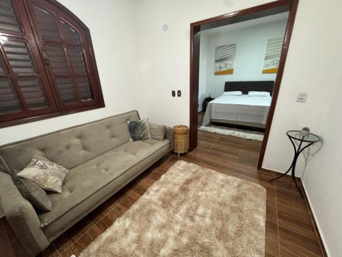 a living room with a couch and a mirror at Quarto Família Aconchegante in Espirito Santo Do Pinhal