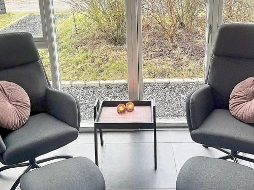 a room with two chairs and a table with two candles at 14 person holiday home in Glesborg in Glesborg